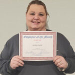 woman holding a employee of the month certificate