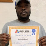 man holding a employee of the month certificate