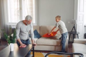 grandson helps grandfather with spring cleaning
