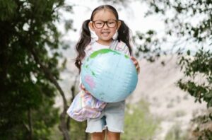 smiling child holds globe
