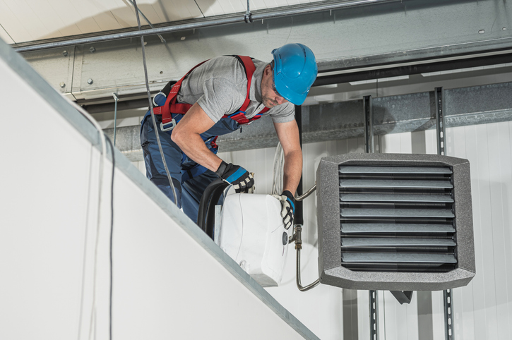 Hvac technician fixing a warehouse system.