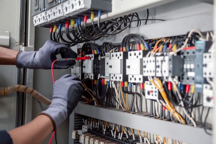 Electricity and electrical maintenance service,Electrical tests industrial electrical circuits with a multimeter in the control terminal box.